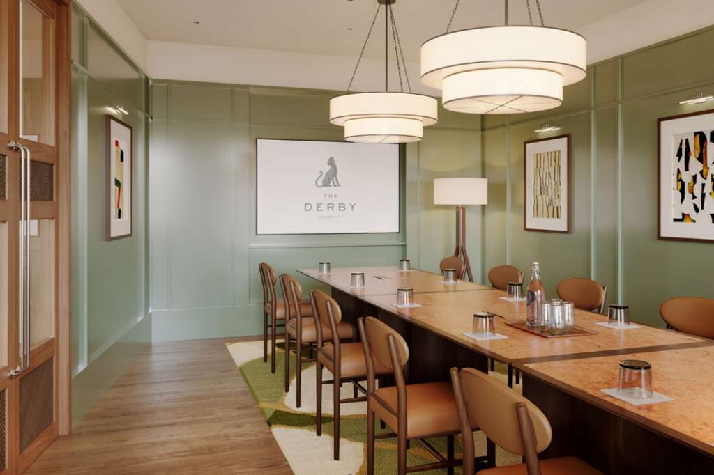 Private dining room with long wooden table, tan leather chairs, green paneled walls, pendant lighting, and Derby branding on screen.