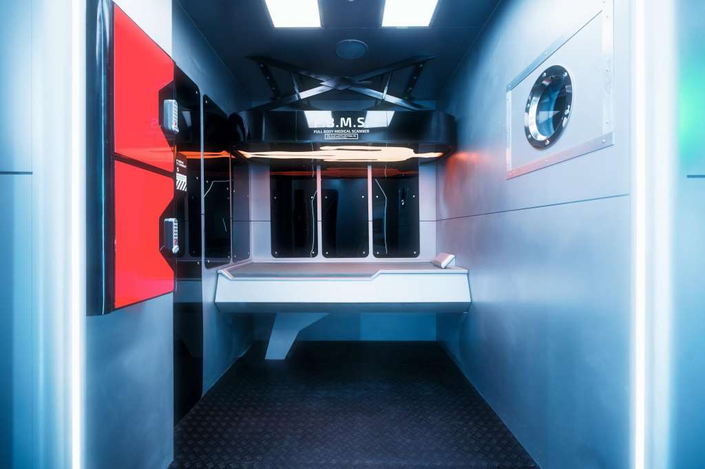 Interior of a ship's bridge or control room with red panel, instrument displays, and navigation equipment.