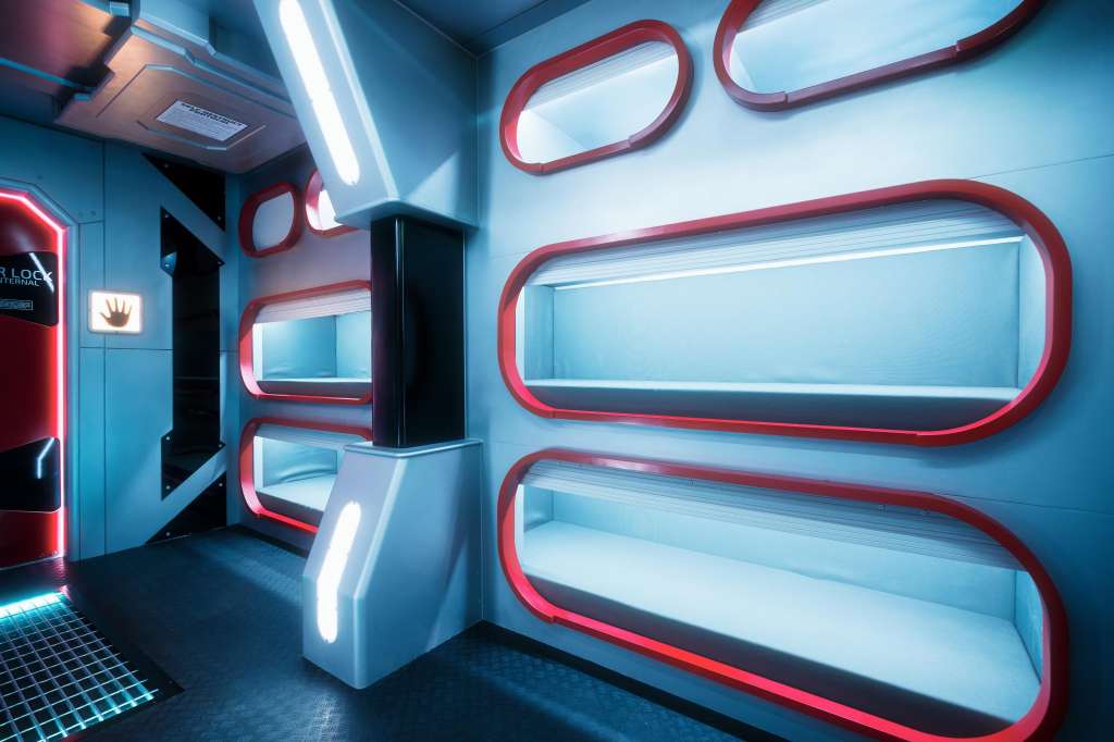 Modern interior with neon red and blue lighting, geometric shelving, and contemporary design elements.