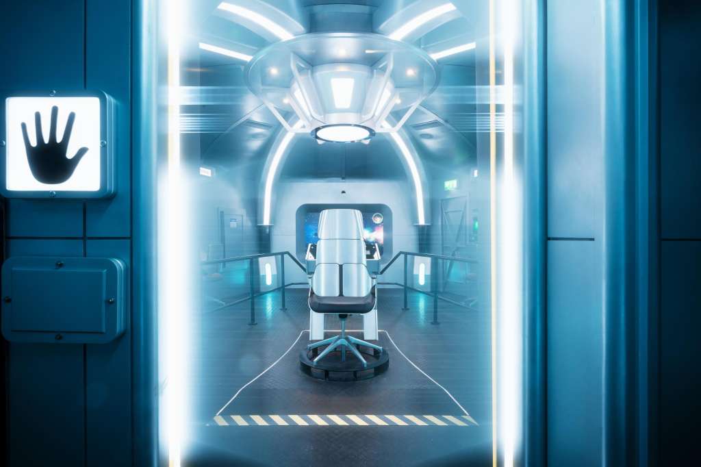 Futuristic corridor with neon lighting, white pod-like structure, and hand symbol sign on wall.