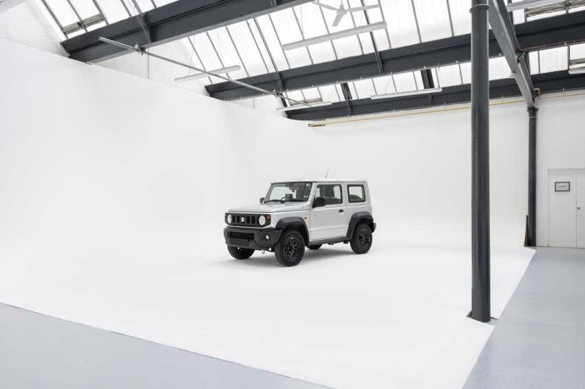White SUV displayed in a bright industrial space with skylights, steel beams, and polished concrete flooring.