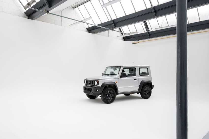 White SUV displayed in a bright industrial space with skylights and exposed steel beams.