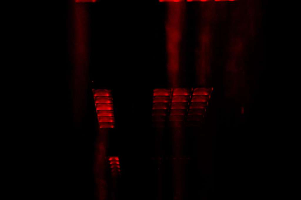 Red atmospheric lighting installation with geometric patterns against dark background.