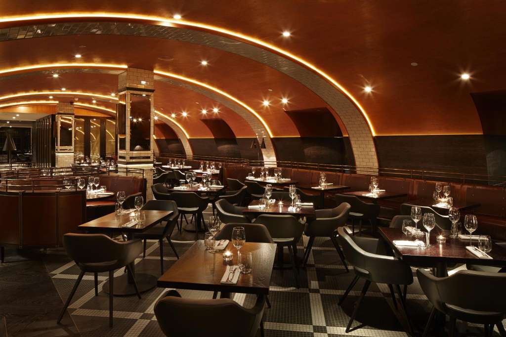 El Salon dining room with curved ceiling, ambient lighting, and tables set with glassware and place settings.