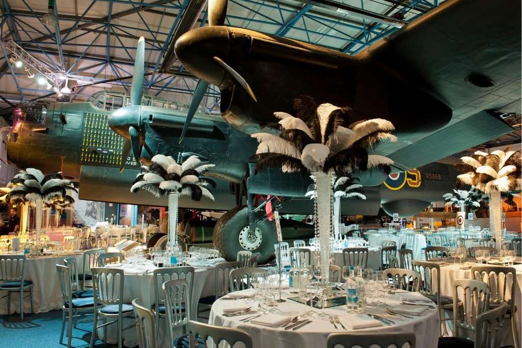 Sunderland Hall set up for a seated dinner with round tables, white linens, and aircraft overhead.
