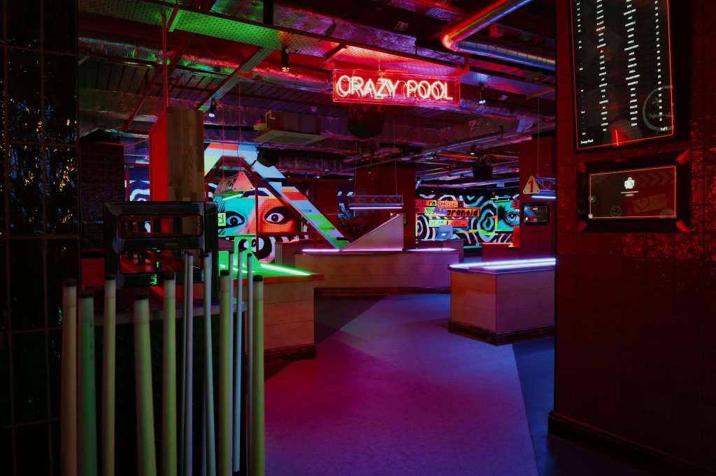VIP Room with neon lighting, colorful wall art, bar seating, and dance floor setup.