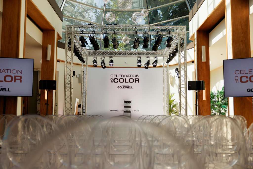 Palm Court set up for product launch with stage, professional lighting rig, branded backdrop, and clear seating area.