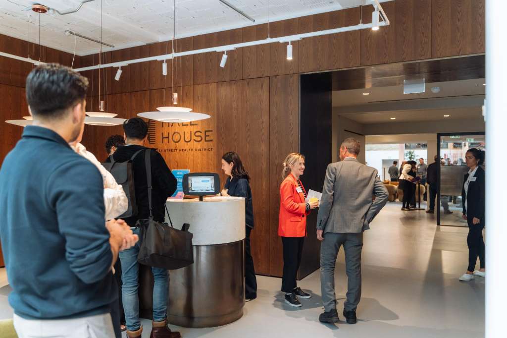 Cormack room with reception desk, pendant lighting, wood paneling, and guests mingling during an event.