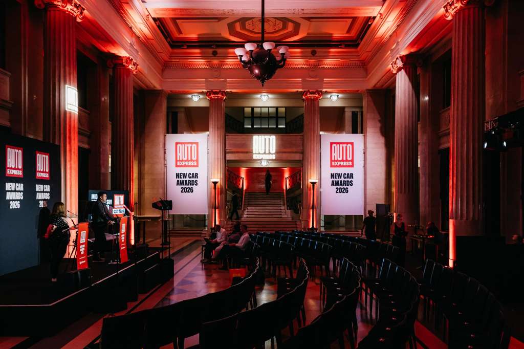 Main Hall set up for product launch with stage, banners, red ambient lighting, and seated audience.