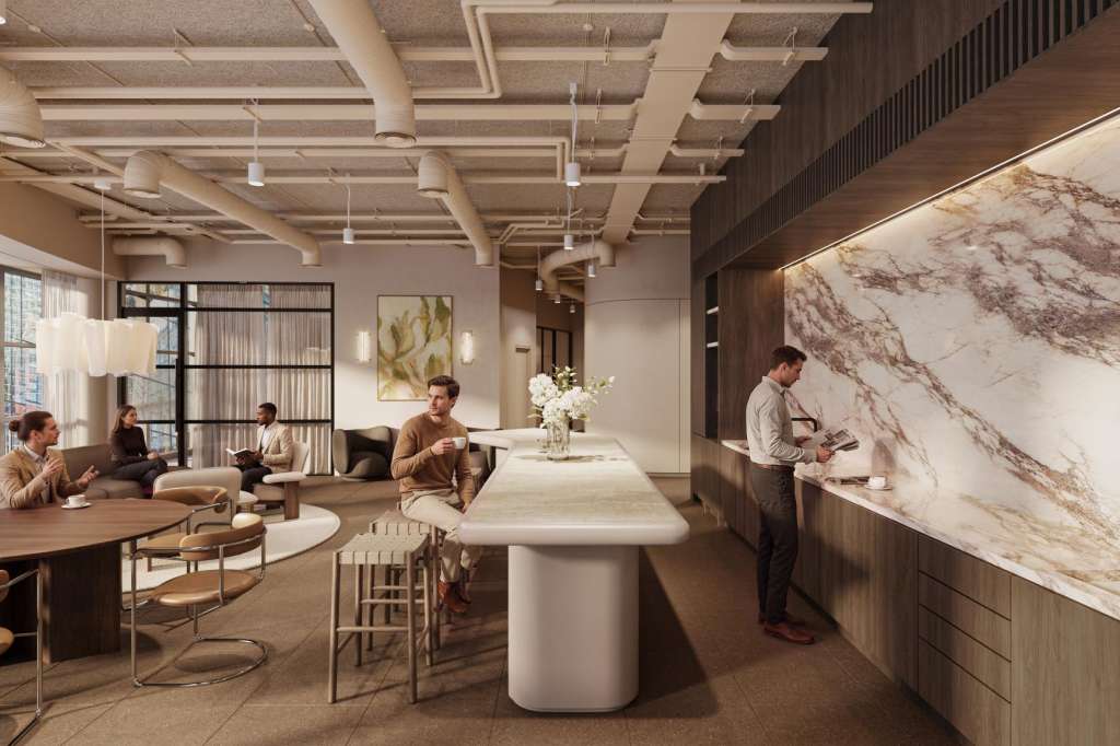 Modern open-plan office space with round tables, bar seating, and contemporary lighting. Multiple people working and conversing.