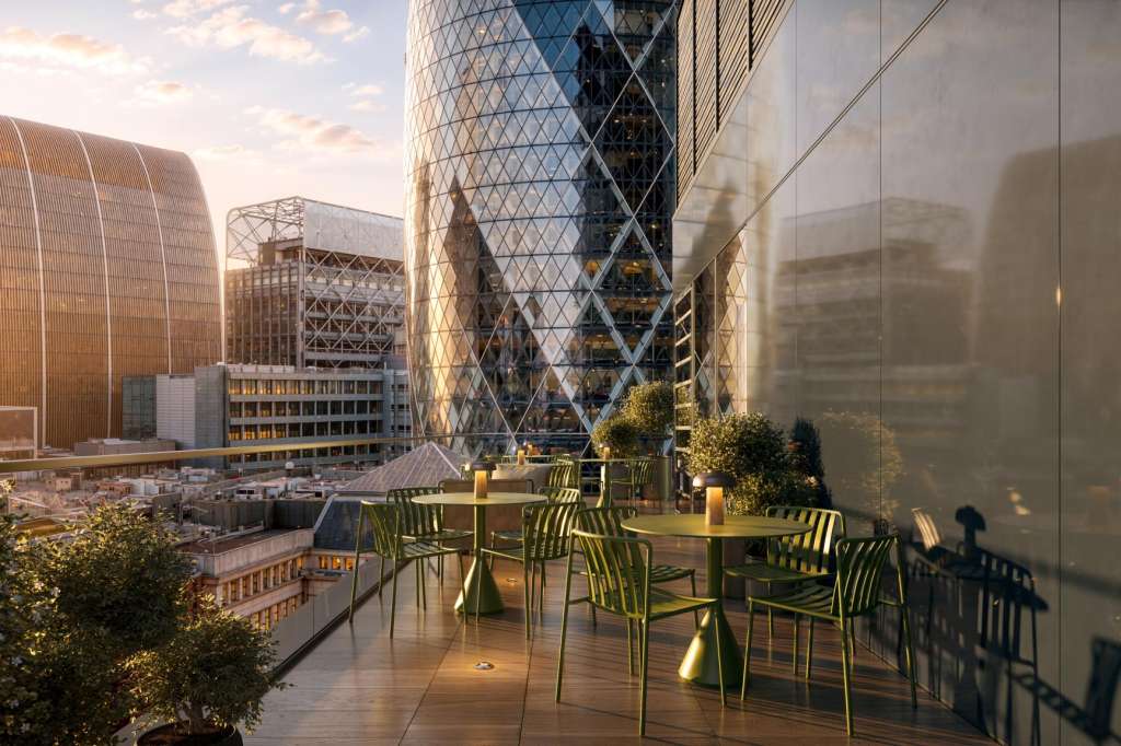 Rooftop terrace with green chairs and tables overlooking a city skyline at sunset.
