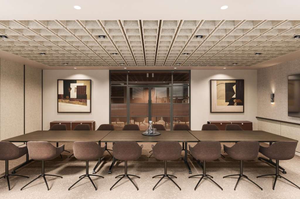 Discovery Project Space with long conference table, brown chairs, recessed ceiling, and framed artwork on walls.