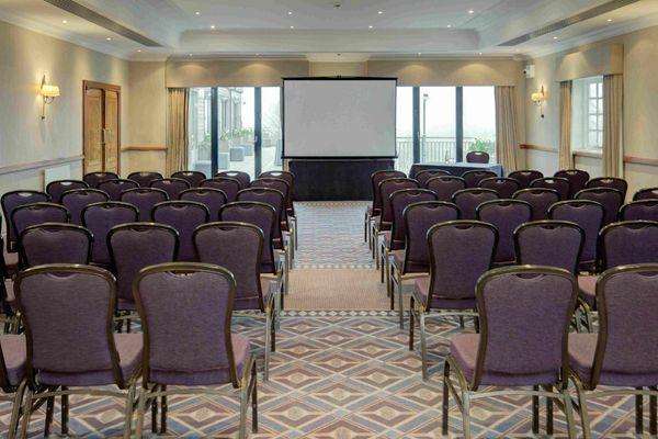 Windmill Suite set up with rows of purple chairs facing a projection screen and stage area.