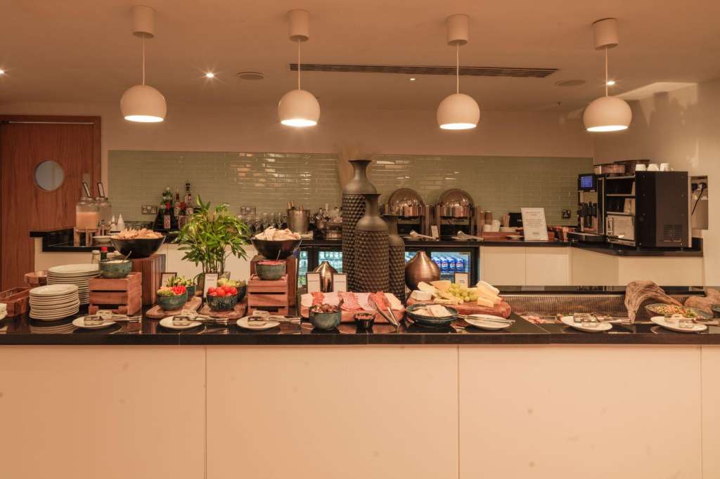 Catering counter with food display, pendant lighting, and beverage service setup.