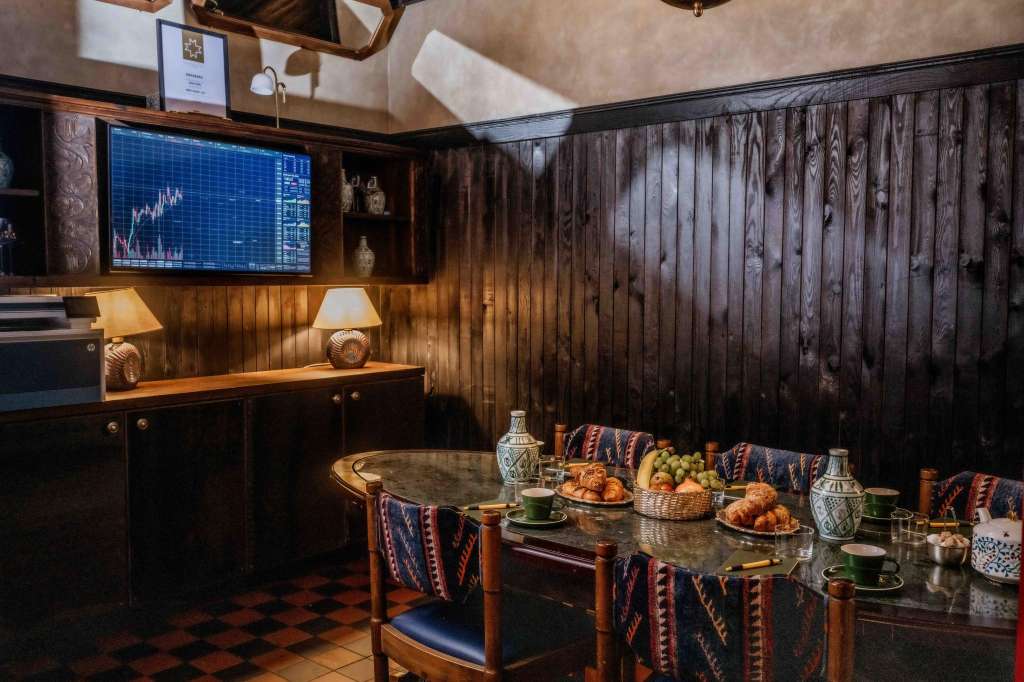 Wine Bar with dark wood paneling, set table with place settings, food platters, and financial display screen.