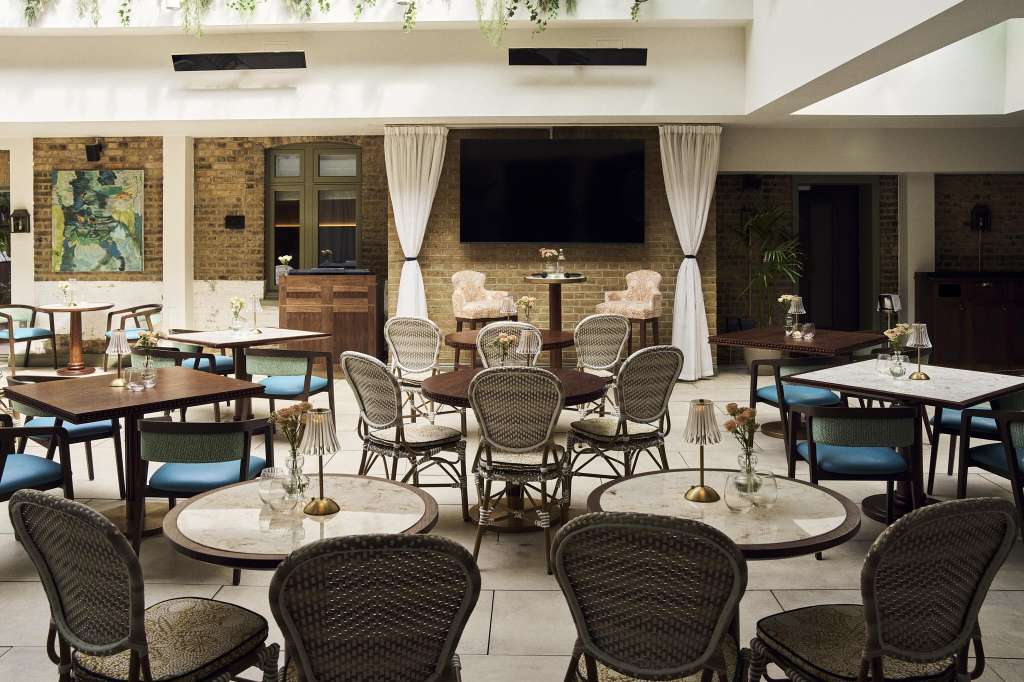 Chelsea Rooms set with round tables, wicker chairs, and cocktail-height seating arranged for a reception or meeting.